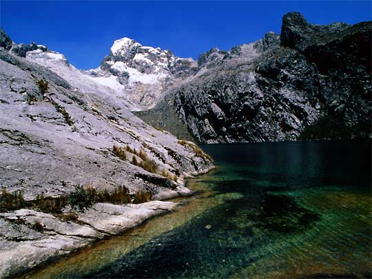  Crystal clear Lago Churuz shimmers under blue sky in Cordillera Blanca