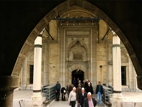  Men spill out of an old mosque at prayer time
