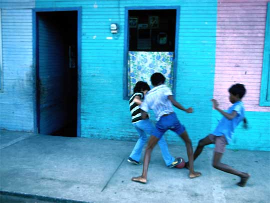 Boys playing football on street in Puerto Limon, central eastern Costa Rica