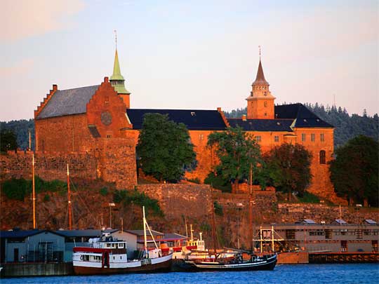  Boats bob below the historic Akershus Fort and Castle in golden light