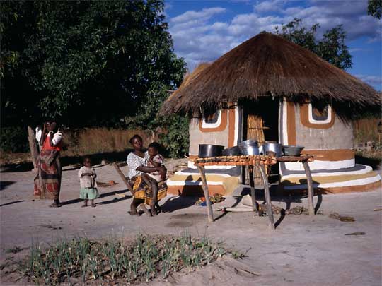  Bemba mother and children in front of their house, Northern Zambia
