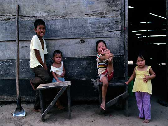  Smiling children play outside a house near Saavedra, Potosí district