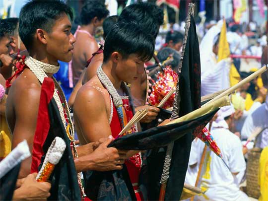 Young men about to pierce themselves with skewers, at Vegetarian Festival