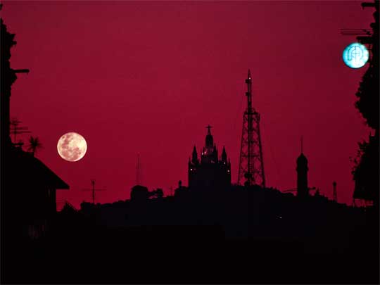  A full moon and a bright street sign vie for attention in the sky over Tibidabo