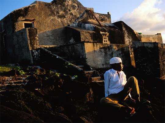  Boy sitting in front of mosque in Moroni, capital of Comoros Islands