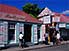 Shoppers passing pastel shop fronts, on Front Street, Philipsburg