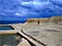 Person strolling around salt pans, admiring carving of snail, at Xweini Bay