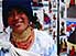 Indigenous woman selling colorful blankets at Otavalo market