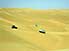 Four wheel drives, looking like child's toys, in Awbari Sand Sea