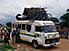 Minibus with two bicycles and half a house on top, outside Abidjan