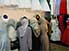 Women, most of them bridesmaids, examining wedding dresses